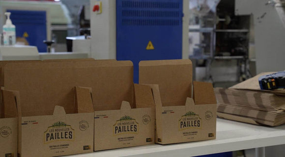 Carton packaging for eco-friendly bagasse straws made in France, displayed in a manufacturing facility.