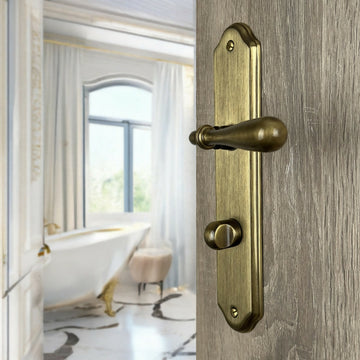 2 poignées de porte sur plaque CARINA, Verrou de condamnation pour salle de bain/WC, Finition laiton patiné, Entraxe standard 195 mm