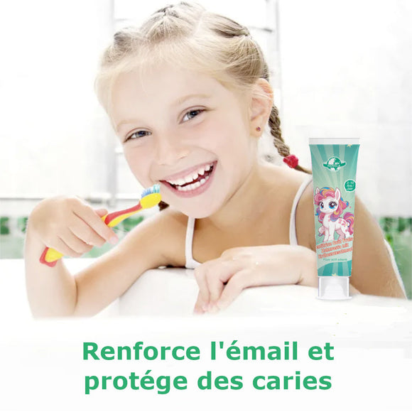 Enfant souriant brossant les dents avec dentifrice à la fraise pour renforcer l'émail et protéger des caries.