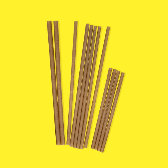 Ensemble de pailles en bagasse sur fond jaune vif, pour cocktails et boissons.